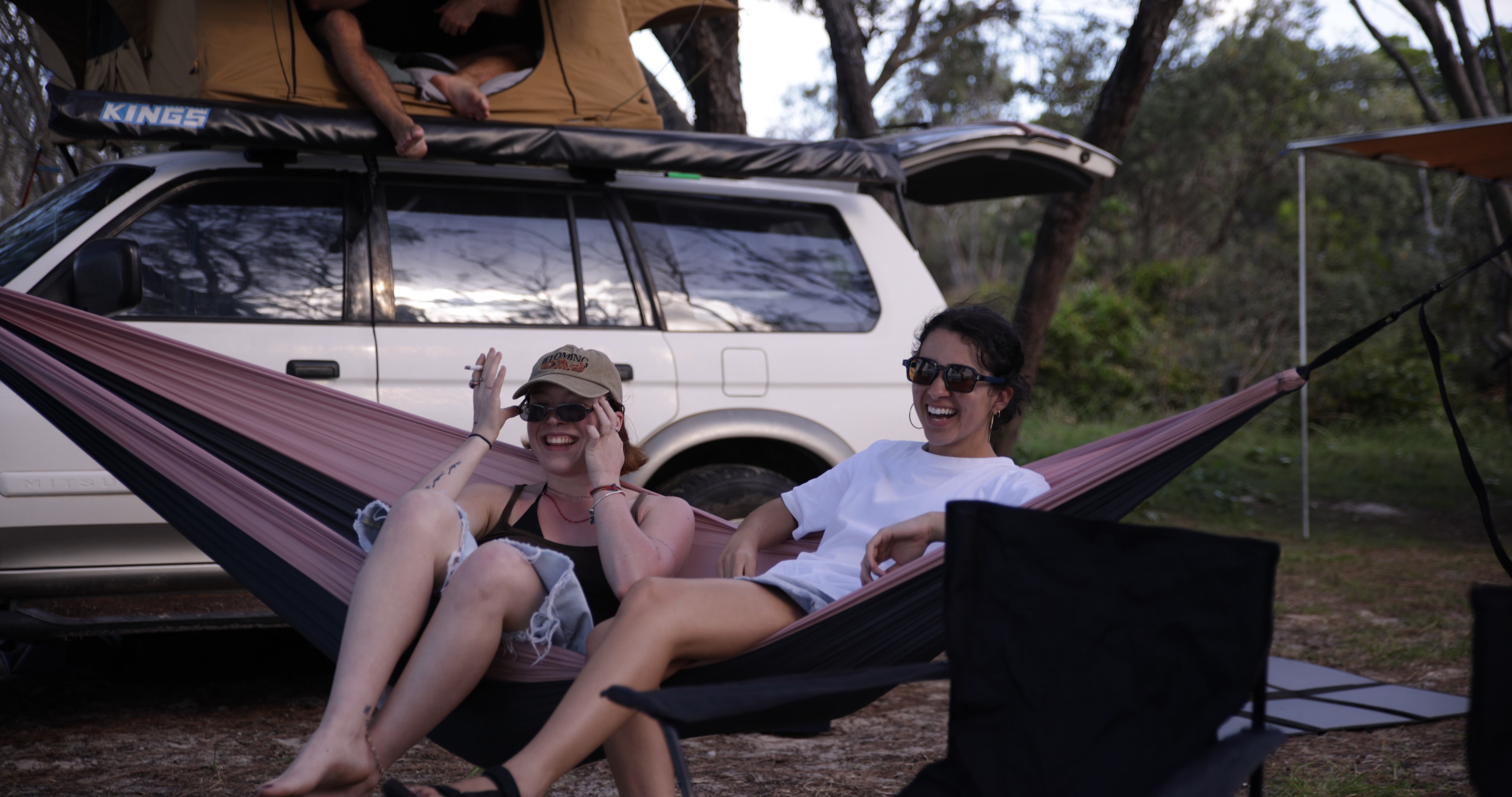 Friends relaxing around camp chairs